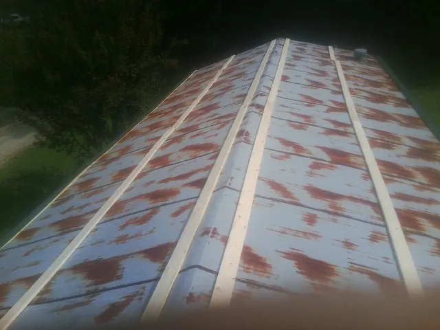 Rusted metal roof panels with new wood purlins before replacement — Storm Damage Roof Repair in Childwold by Roofing Brothers